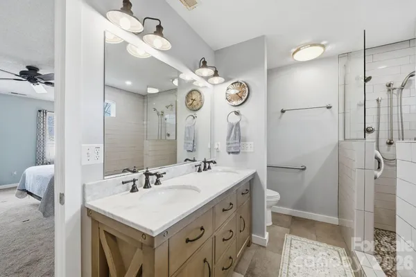 a bathroom with a double vanity sink mirror and shower
