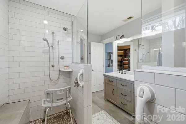 a bathroom with a double vanity sink a toilet and shower