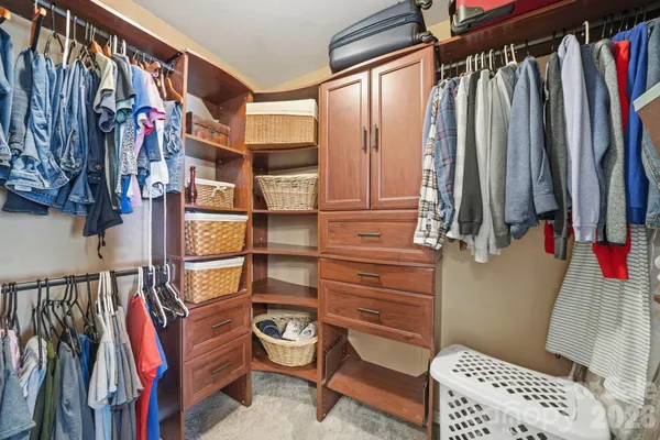 a view of walk in closet with clothes and shoes