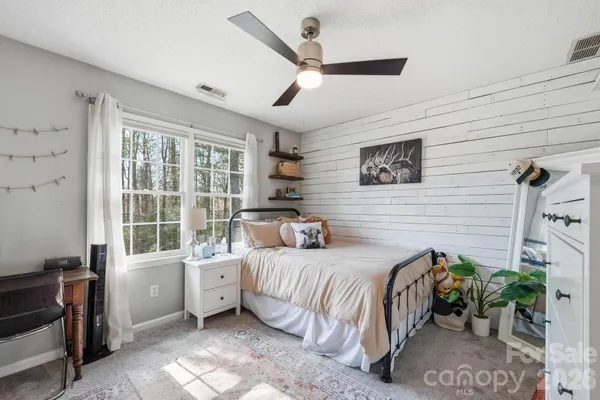 a bedroom with a bed table and a window