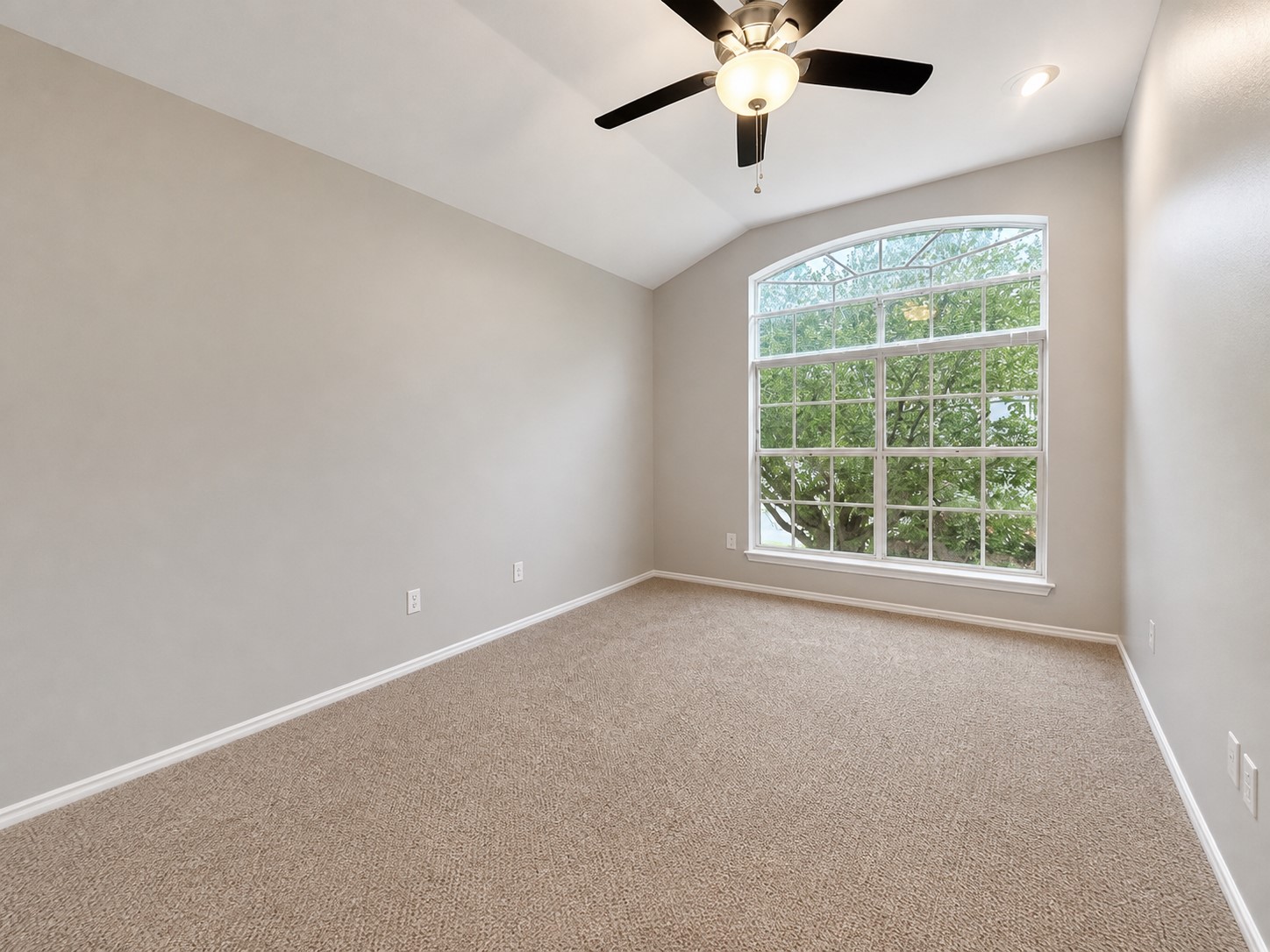 14828 Single Trace Austin, TX 78728 - Photo 21 of 30 Vaulted ceiling room featuring a large arched window, light beige carpeting, and a ceiling fan with integrated lighting