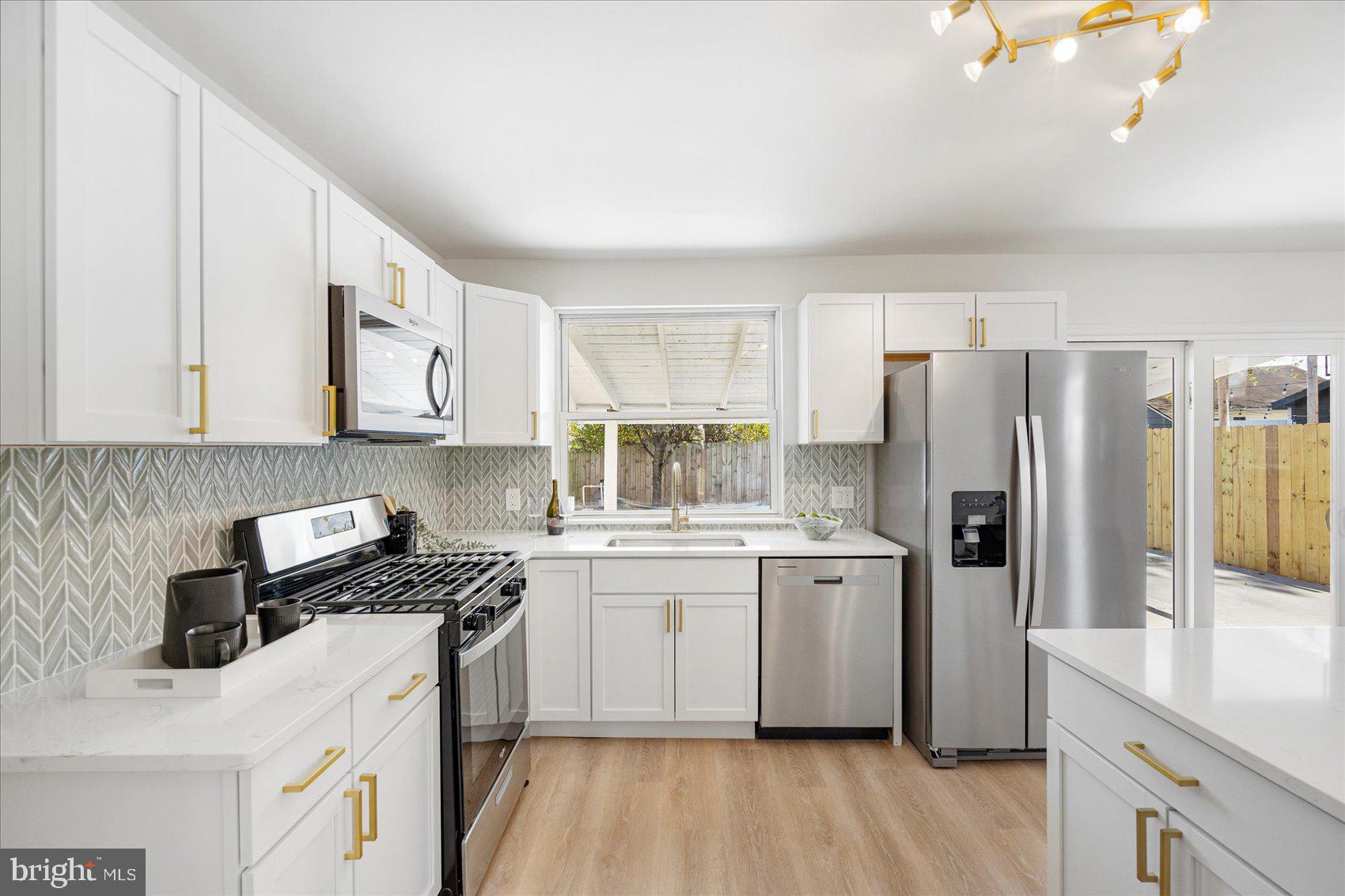 7803 Brevort Road Windsor Mill, MD 21244 - Photo 19 of 45 a kitchen with a stove a sink and a refrigerator