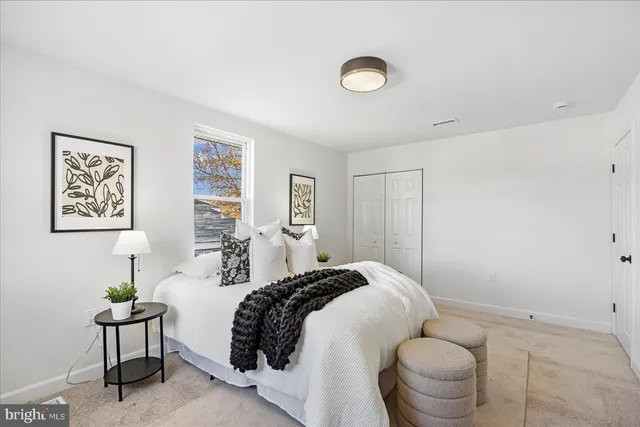 a spacious bedroom with a bed and a lamp