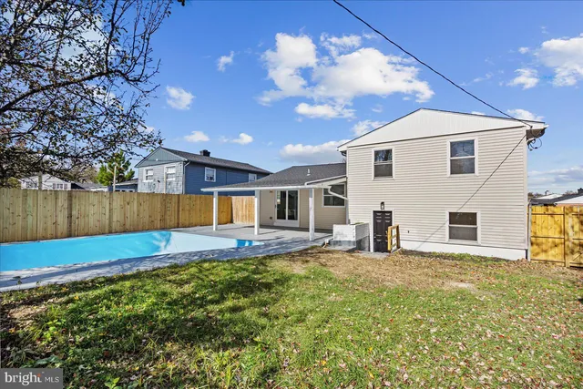 a view of a house with a yard and fire pit