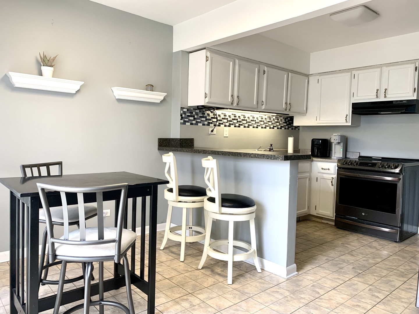 2231 Flower Court, Unit 2231 Schaumburg, IL 60107 - Photo 5 of 24 a kitchen with stainless steel appliances kitchen island granite countertop a table and chairs in it