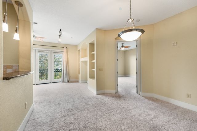 a view of a big room with windows and chandelier
