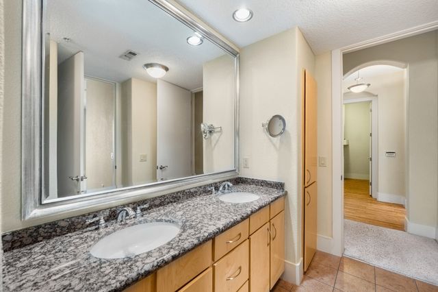 a bathroom with a granite countertop sink and a mirror
