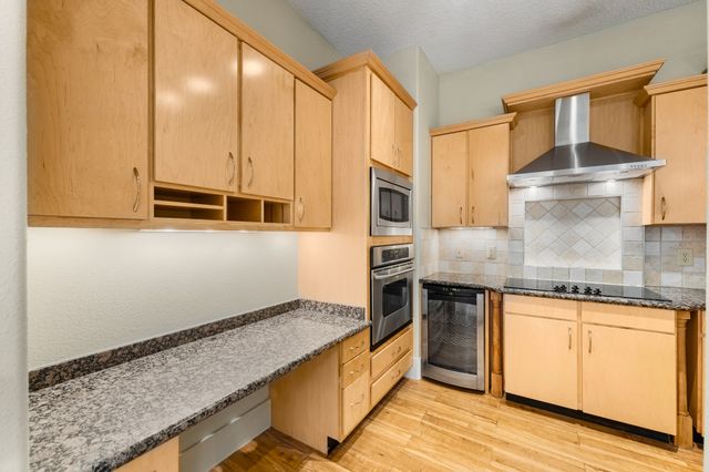 a kitchen with stainless steel appliances granite countertop a stove a sink and a microwave