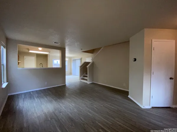 an empty room with wooden floor and a window