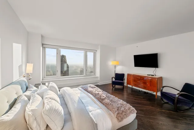 a bedroom with a bed and large windows