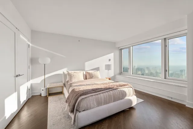 a bedroom with a bed and a large window