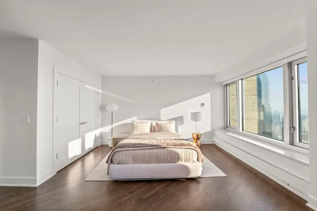 a spacious bedroom with a bed and a large window