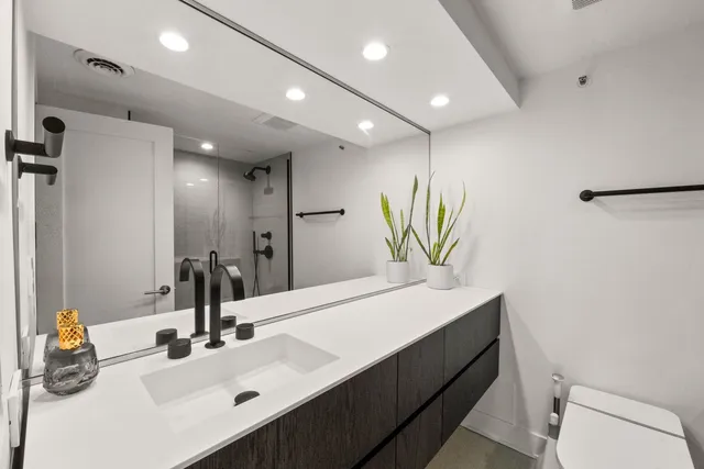 a bathroom with a sink a toilet and a mirror