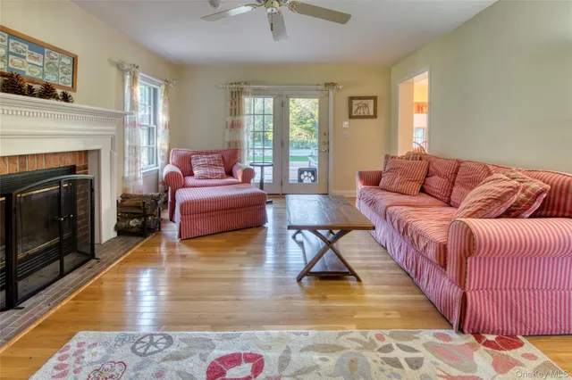 a living room with furniture hard wood floor and a fireplace