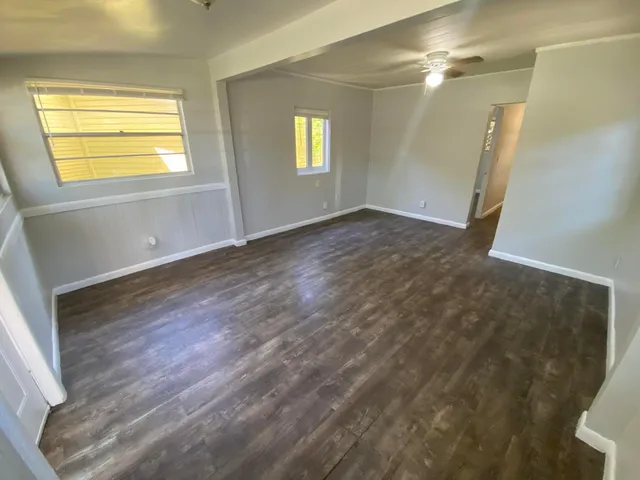 a view of empty room with wooden floor