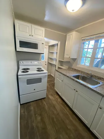 a kitchen with granite countertop a sink a granite counter tops and a large window