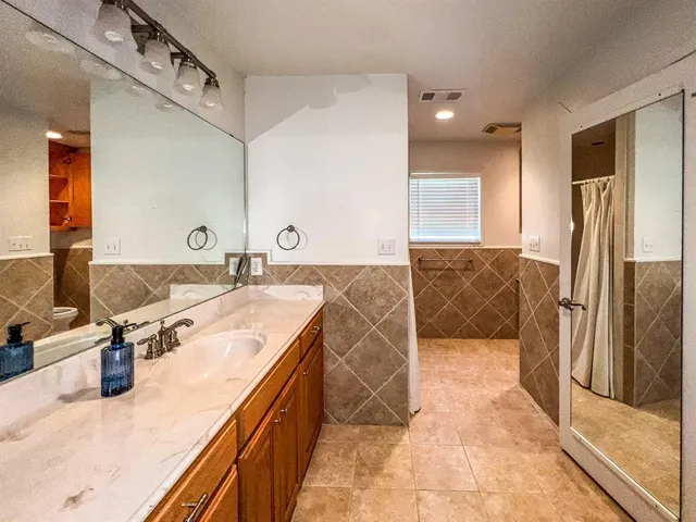a spacious bathroom with a double vanity sink and a mirror