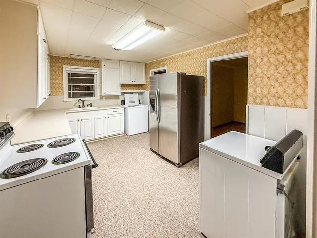 a kitchen with a refrigerator sink stove and cabinets