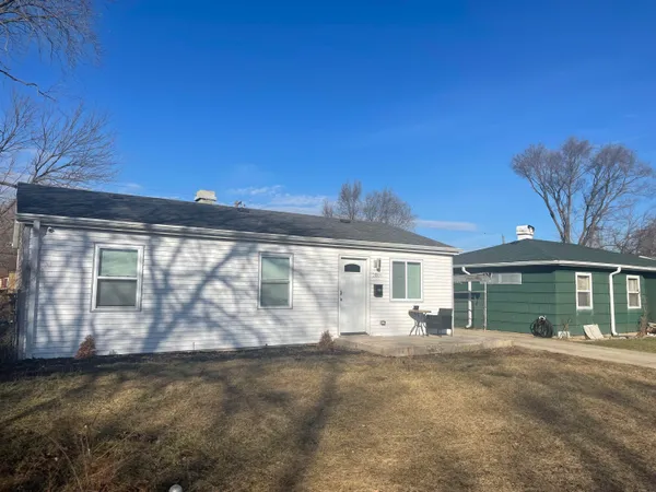 a view of a house with backyard and a tree