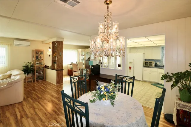 a view of a dining room and livingroom with furniture wooden floor a chandelier