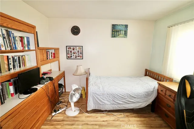 a bedroom with a bed and wooden floor