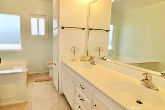 a spacious bathroom with a tub sink and mirror
