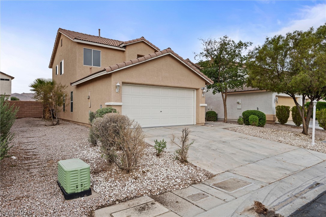 2650 Whisper Ridge Street Las Vegas, NV 89156 - Photo 26 of 28 Two-story home features a classic stucco exterior and concrete driveway with low-maintenance desert landscaping.