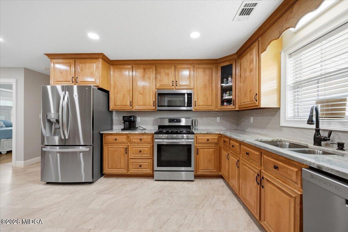 557 Aarons Circle Gray, GA 31032 - Photo 10 of 36 a kitchen with granite countertop a refrigerator stove and microwave