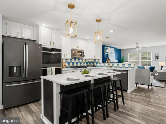 a kitchen with stainless steel appliances kitchen island granite countertop a kitchen island a stove a table and chairs