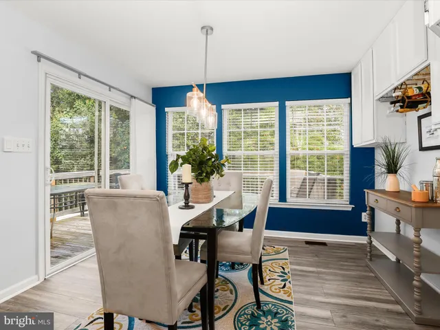a dining room with furniture a chandelier and wooden floor