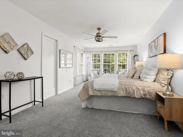 a spacious bedroom with a bed and a window