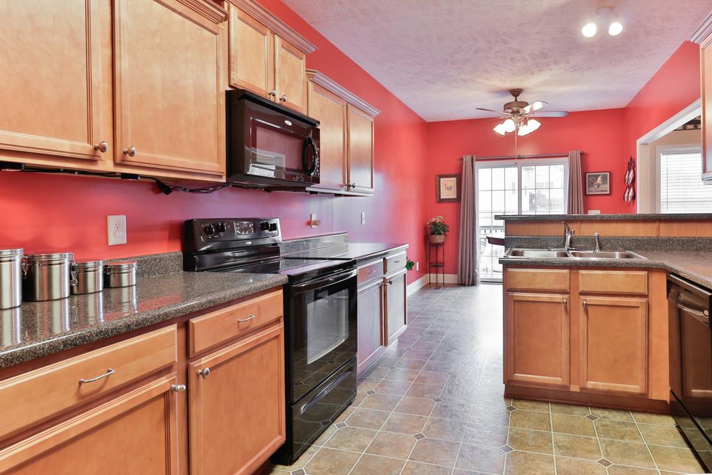 1045 Golf View Way Spring Hill, TN 37174 - Photo 12 of 26 a kitchen with stainless steel appliances granite countertop a sink stove and microwave