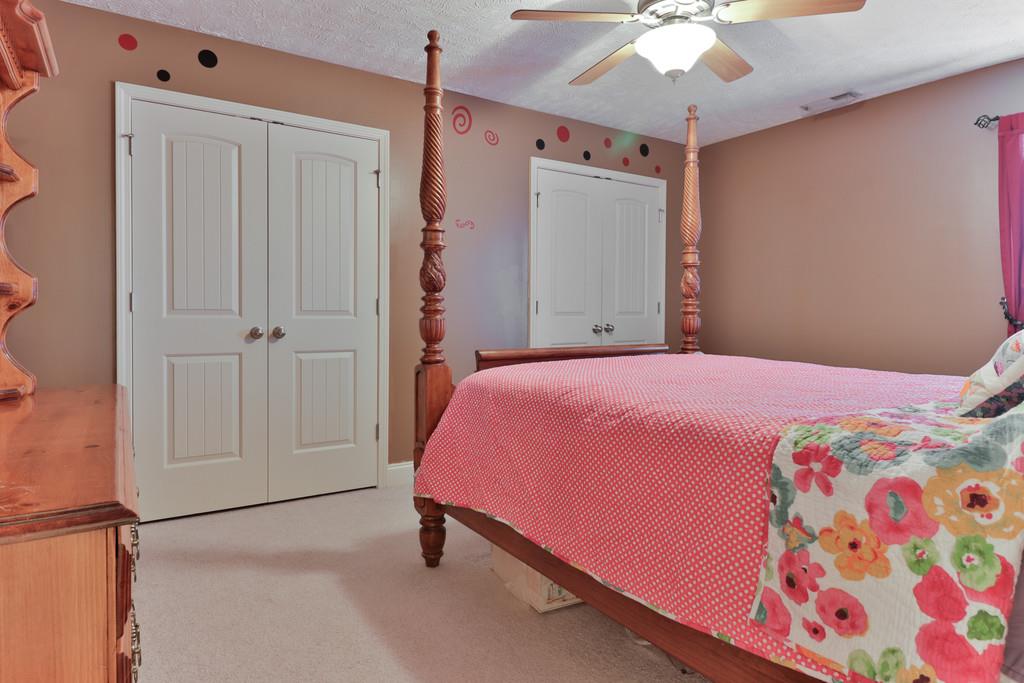 1045 Golf View Way Spring Hill, TN 37174 - Photo 19 of 26 a bedroom with a bed and a chandelier