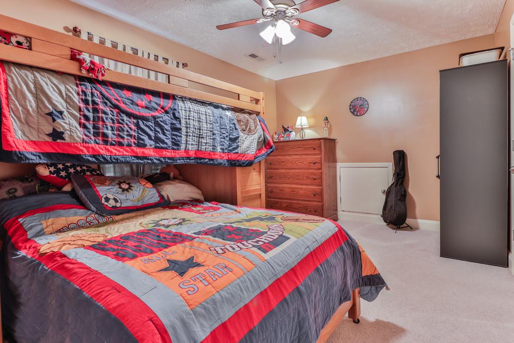 1045 Golf View Way Spring Hill, TN 37174 - Photo 21 of 26 a bedroom with a bed and a chandelier