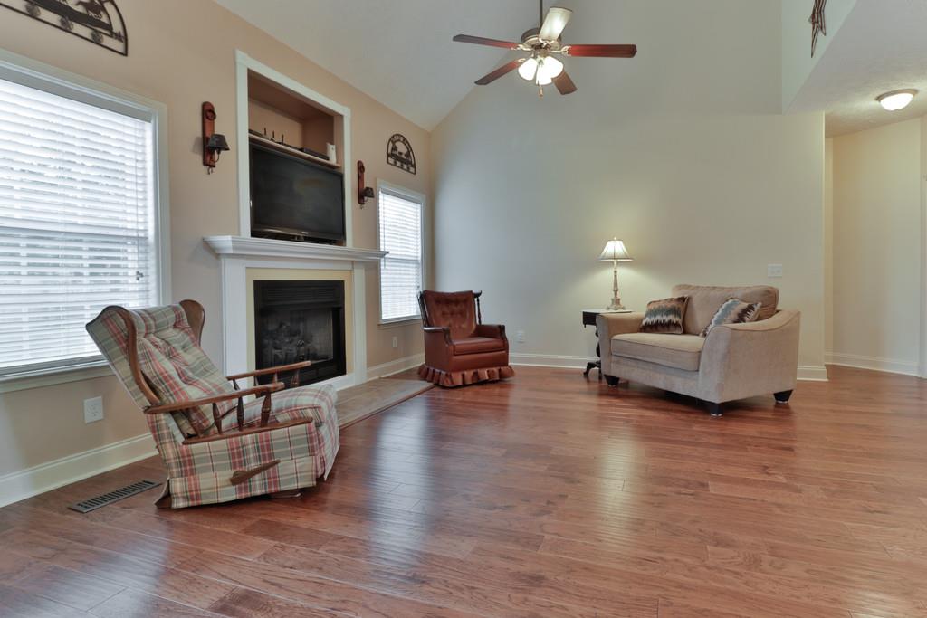 1045 Golf View Way Spring Hill, TN 37174 - Photo 5 of 26 a living room with furniture a fireplace and a flat screen tv