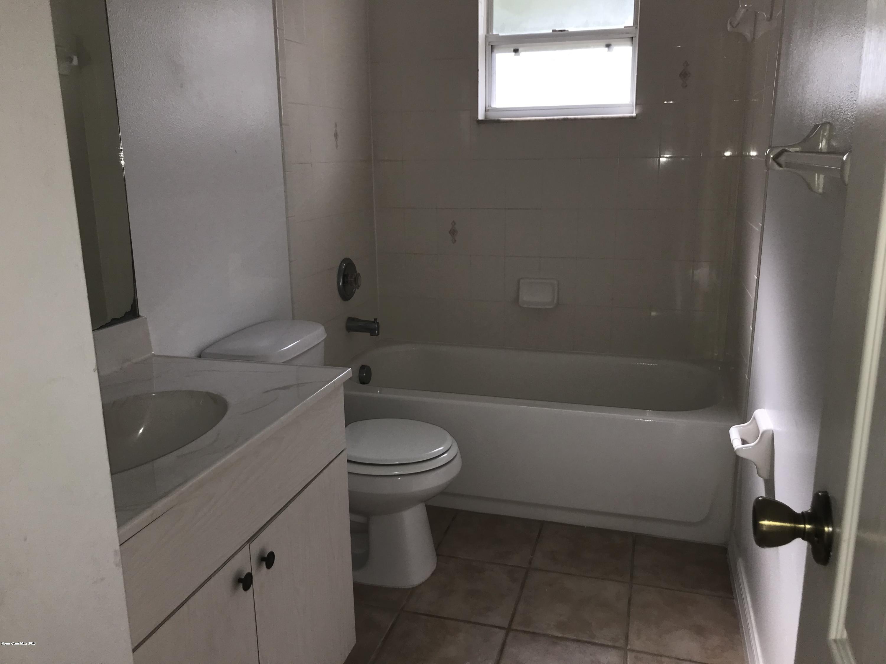 524 Titan Road Southeast Palm Bay, FL 32909 - Photo 14 of 18 a bathroom with a toilet a sink and bathtub