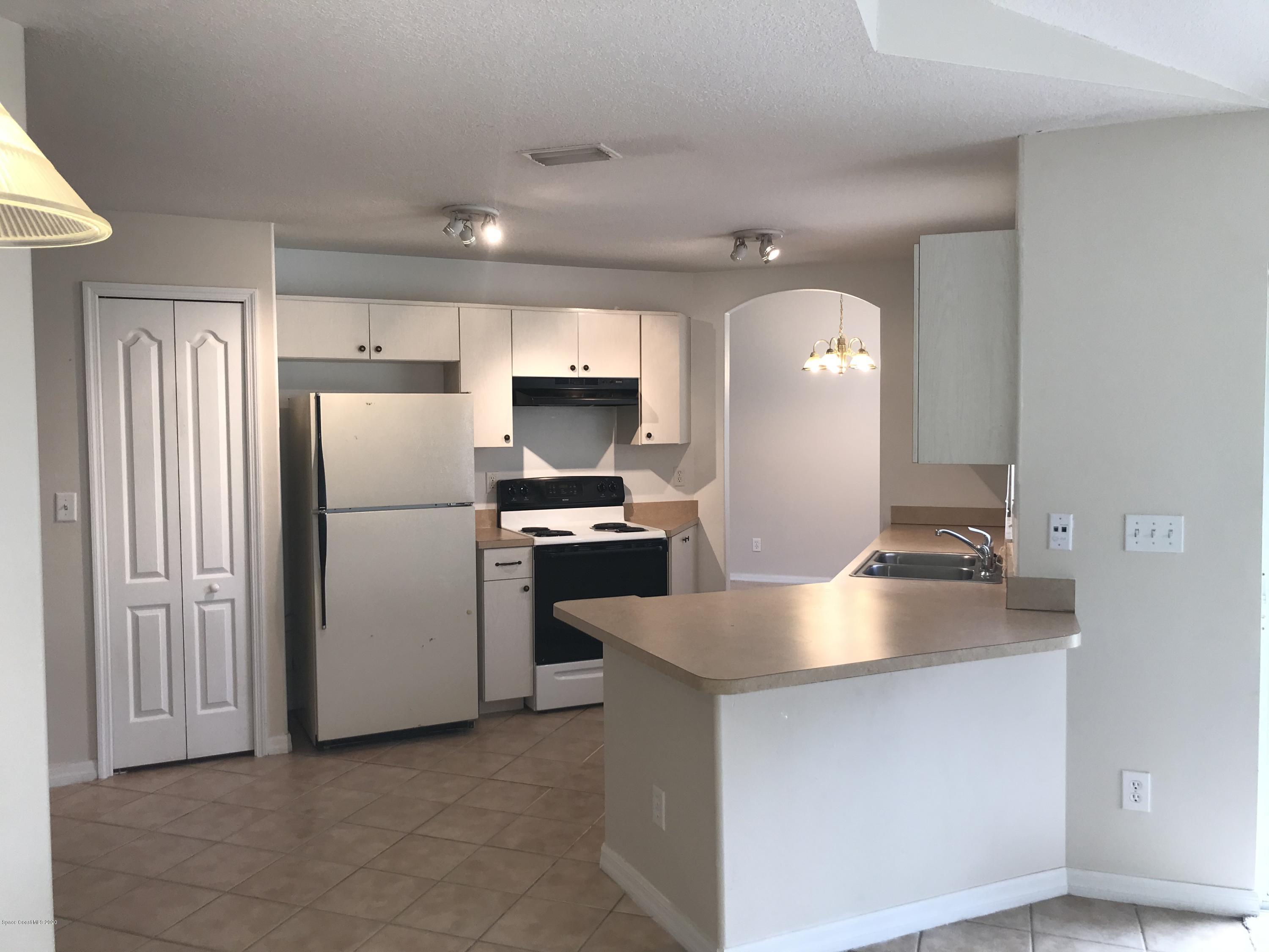 524 Titan Road Southeast Palm Bay, FL 32909 - Photo 3 of 18 a kitchen with refrigerator and white cabinets