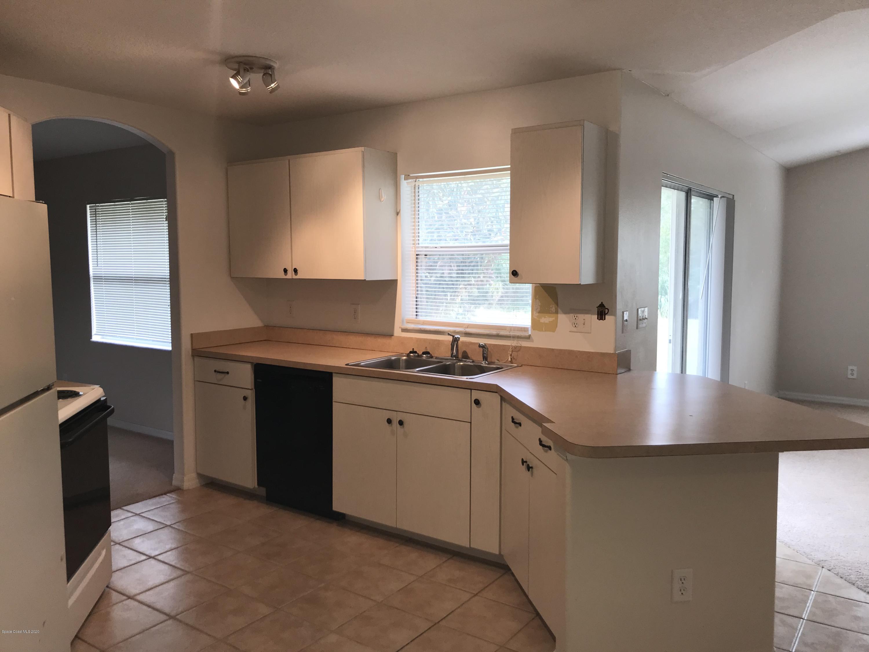 524 Titan Road Southeast Palm Bay, FL 32909 - Photo 4 of 18 a kitchen with stainless steel appliances granite countertop a sink stove and cabinets