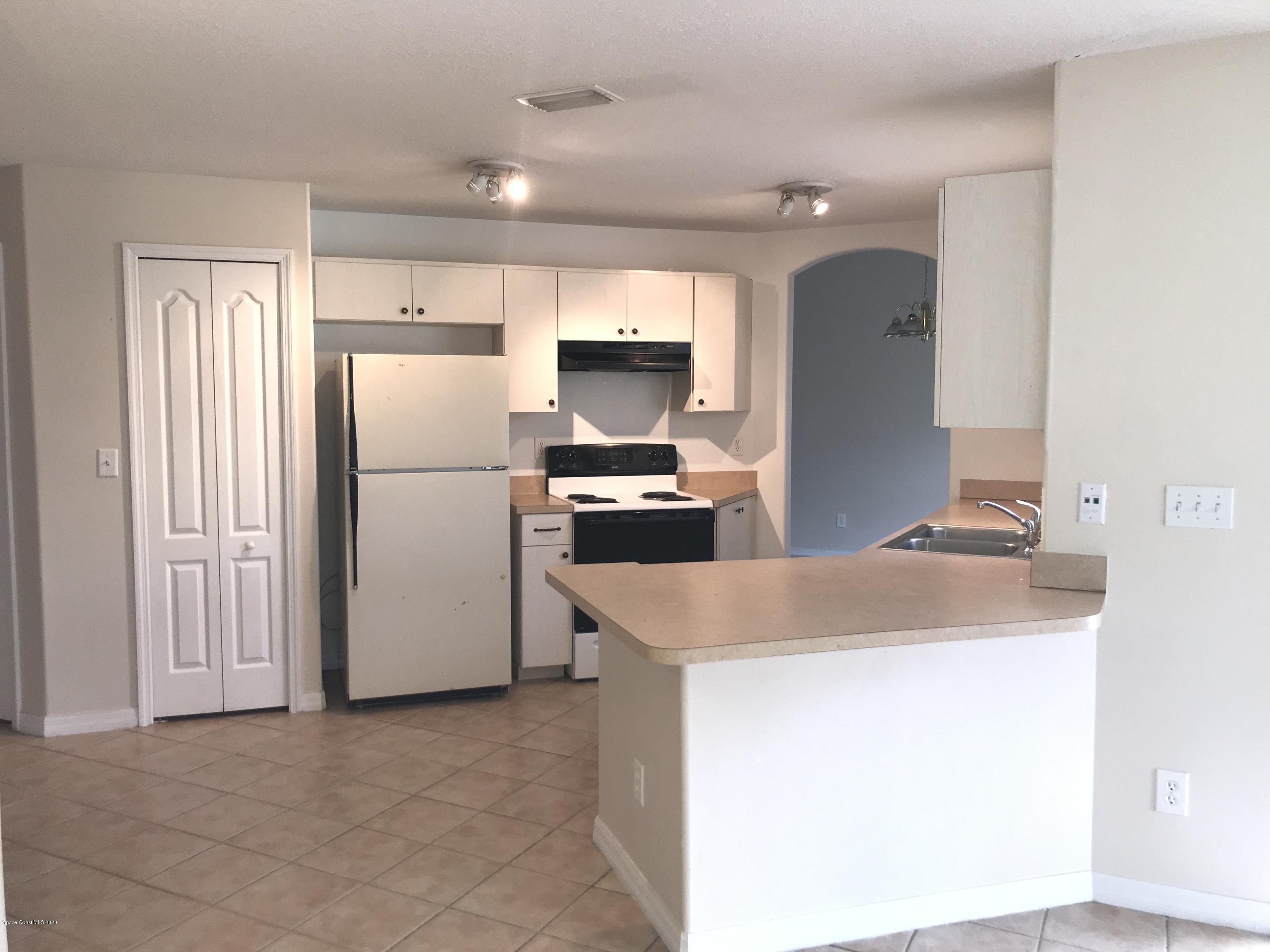 524 Titan Road Southeast Palm Bay, FL 32909 - Photo 5 of 18 a kitchen with a refrigerator and a sink