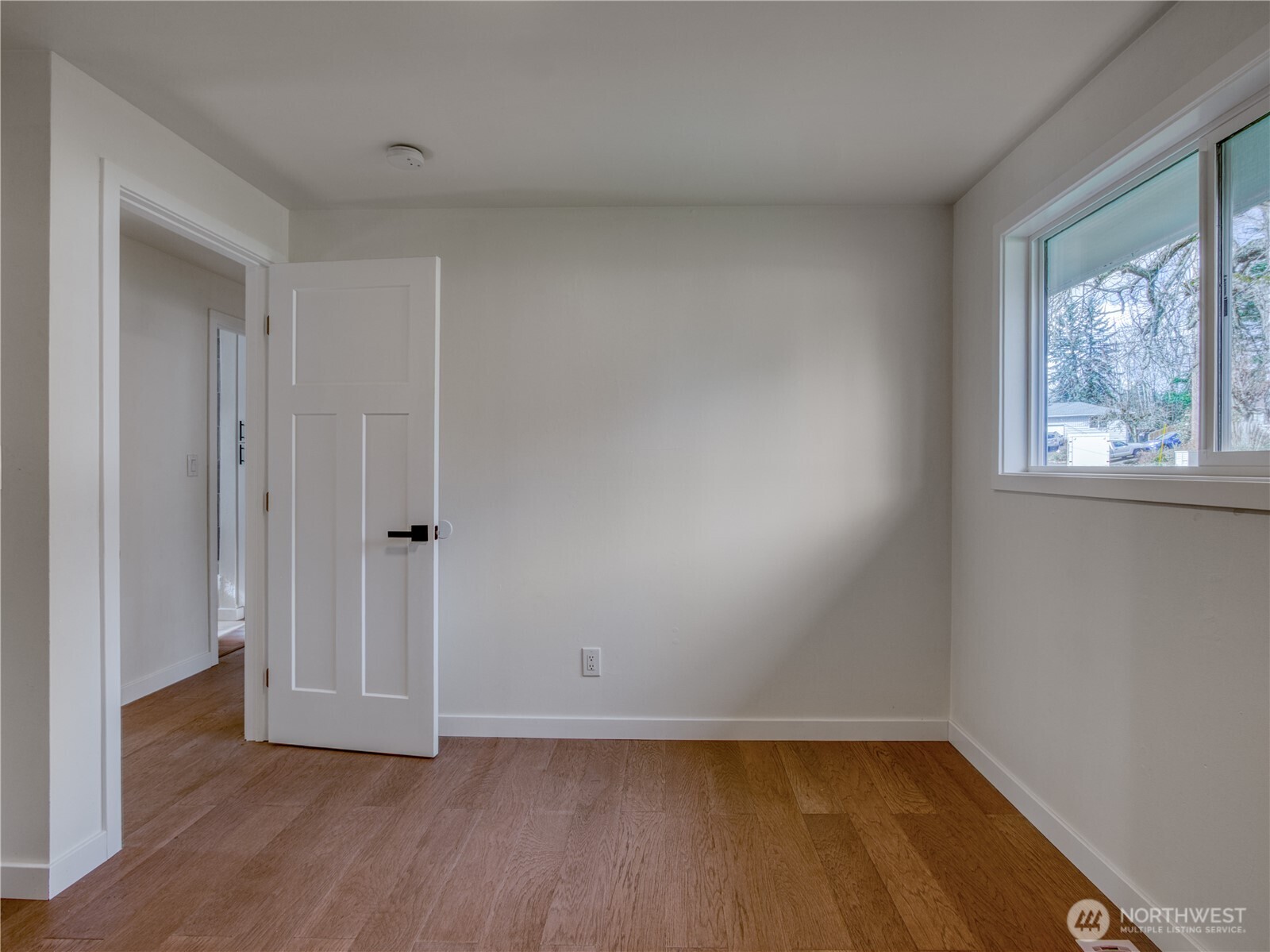 18 232nd Place Southwest Bothell, WA 98021 - Photo 21 of 32 a view of an empty room with wooden floor and a window