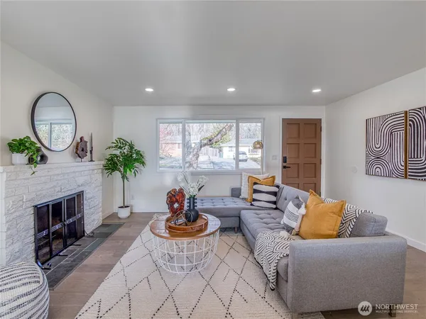 a living room with furniture a fireplace and a large window