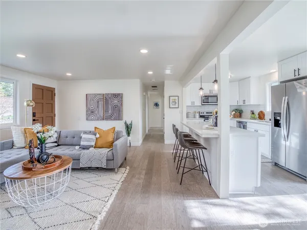 a living room with furniture and a dining table with kitchen view