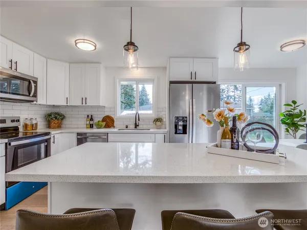 a kitchen with stainless steel appliances granite countertop a sink a stove and a refrigerator