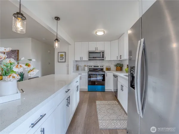 a kitchen with kitchen island a counter top space stainless steel appliances and cabinets
