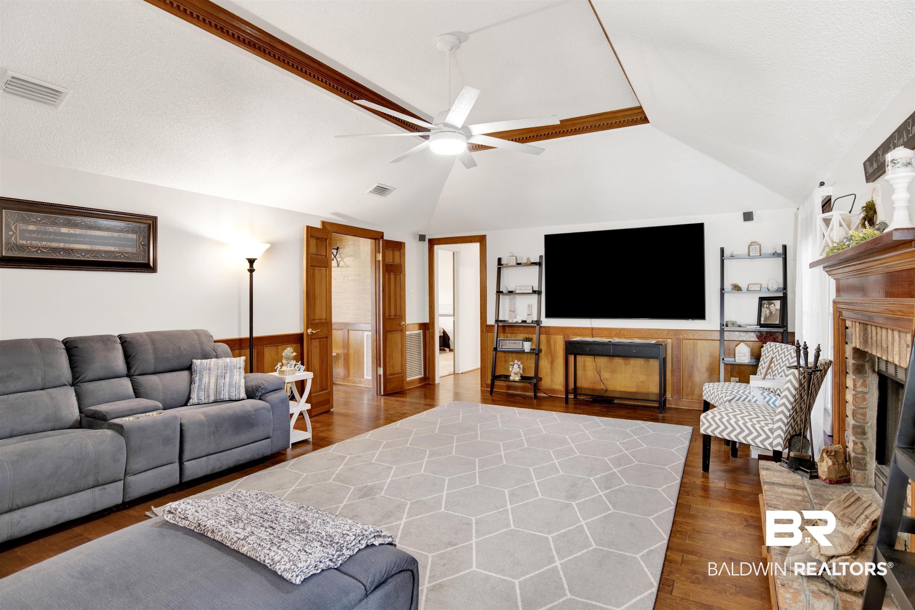 7431 Summer Court Mobile, AL 36695 - Photo 19 of 37 Living room featuring a fireplace, a ceiling fan, vaulted ceiling, and wood finished floors