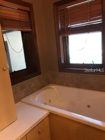 a bathroom with a bathtub and a window