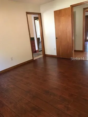 an empty room with wooden floor and closet