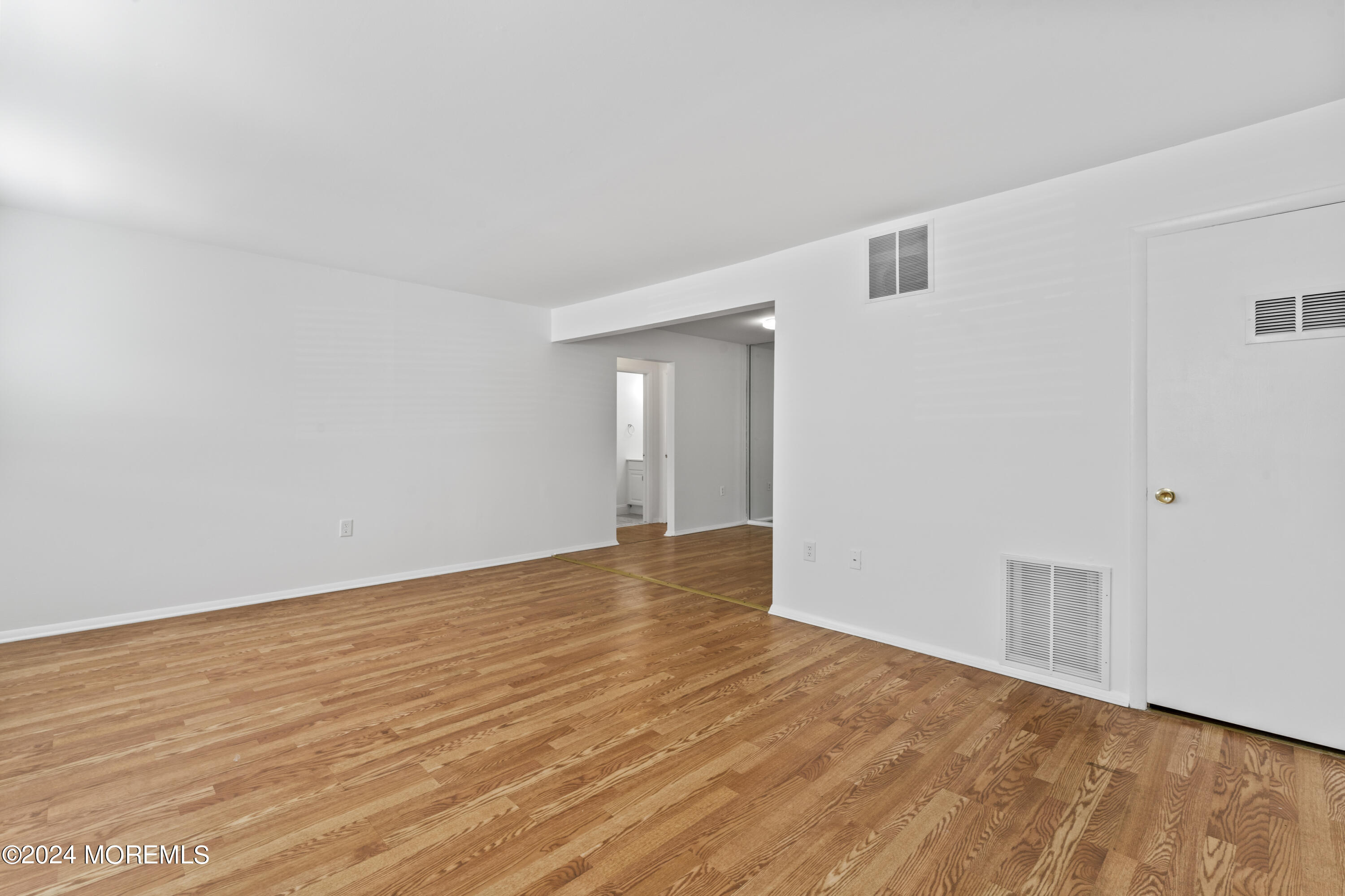 601 Mistletoe Avenue, Unit 4 Point Pleasant, NJ 08742 - Photo 4 of 28 a view of an empty room with wooden floor and a window