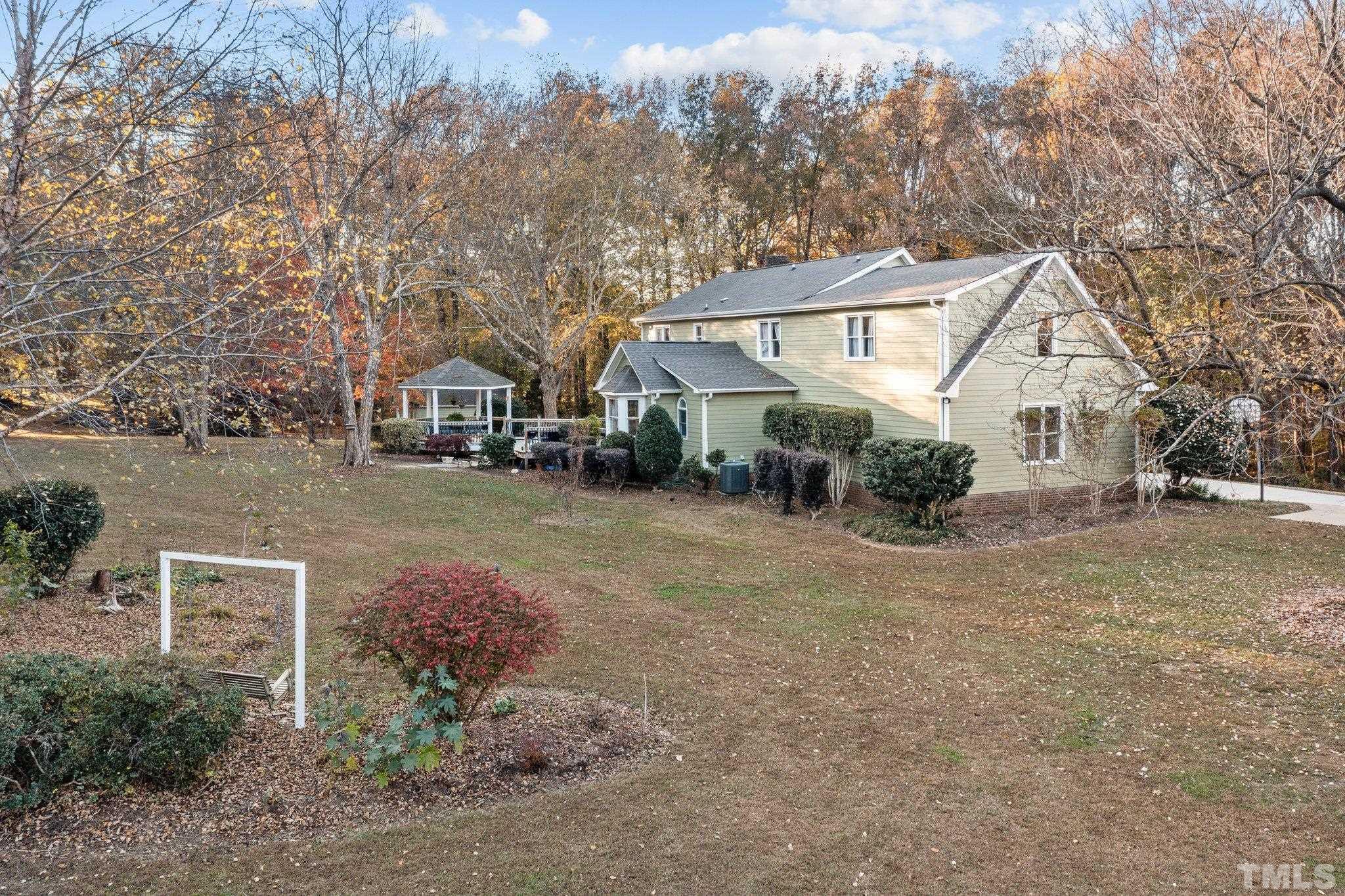 924 Windrow Lane Raleigh, NC 27603 - Photo 10 of 26 a view of a big house with a big yard and large trees