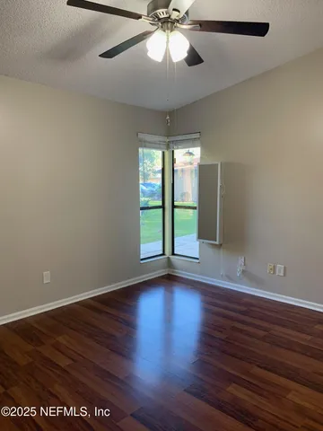 a view of an empty room with wooden floor